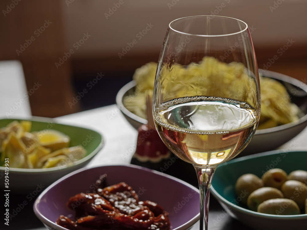 Filled aperitif bowls and a glass of white wine