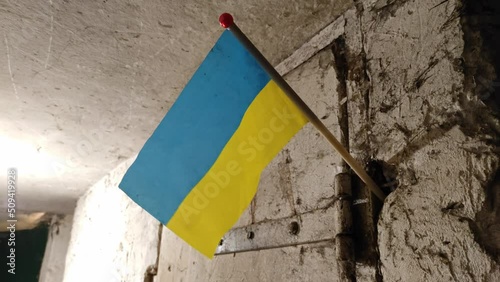 Ukrainian national flag on a wall in a bomb shelter. War of Russia against Ukraine.