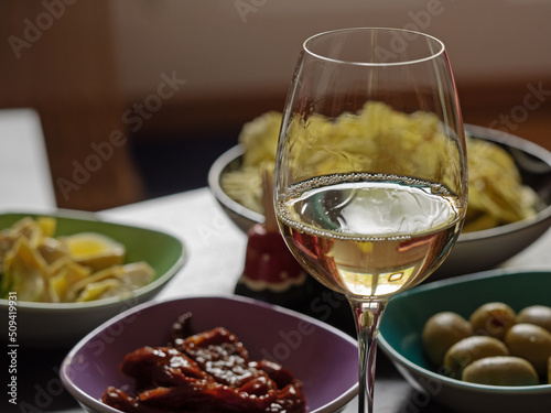 Filled aperitif bowls and a glass of white wine