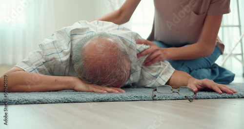 Elderly Asian man fell on the floor and fainted in the living room.Elderly caregivers came to help urgently.Daughter was shocked to see her father fall to the ground.Elderly health problems concept.