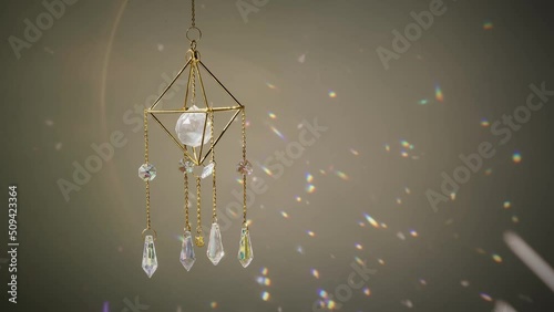 Close up crystal sun catcher in front of the wall at sunset time. Indoors. Good Feng Shui, energy flow concept. 4K UHD