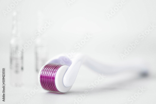 White microneedling derma roller with cosmetic ampoules photo