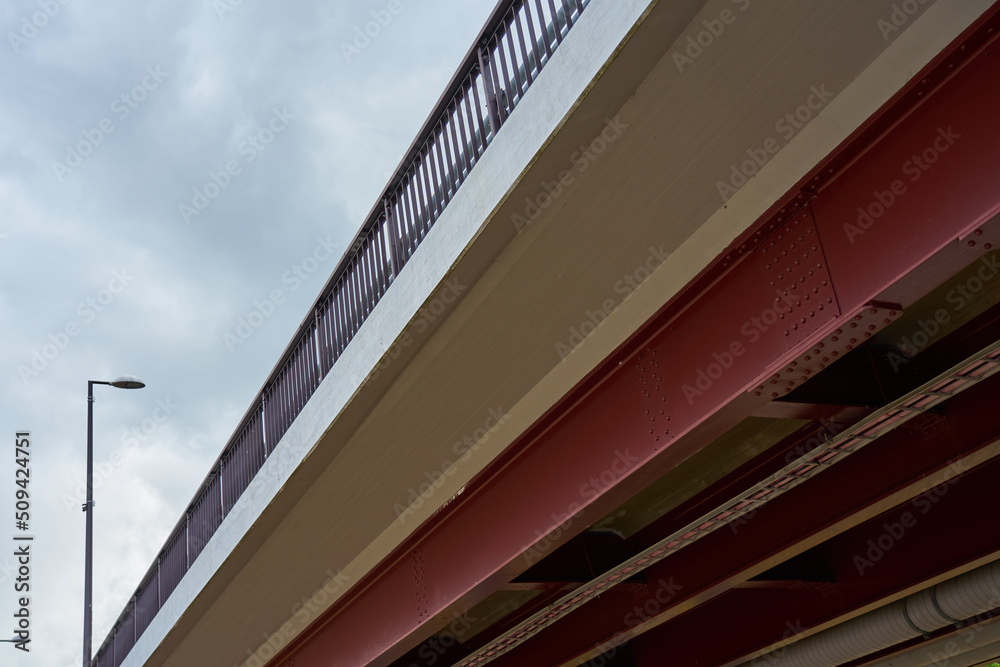 Fototapeta premium Metal bridge view from below with an overcast sky in the background.