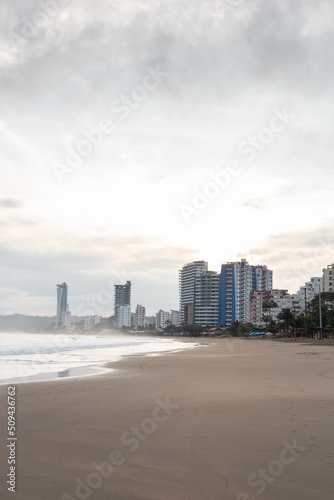 landscape with city on the edge of the beach, exterior architecture with buildings, detail of sea and sand of the coast, scene as background © Alejandro