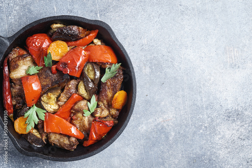 Beef roast with sauteed bell pepper and other vegetables on pan, top view with copy space