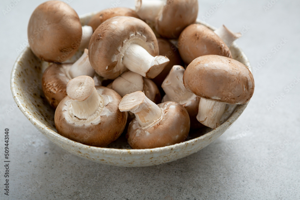 Close up of raw fresh champignon mushrooms in bowl Close up of raw fresh champignon mushrooms in bowl