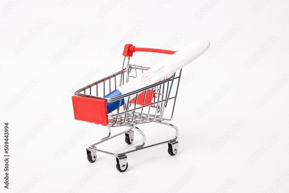 Pregnancy test in a shopping cart on white background