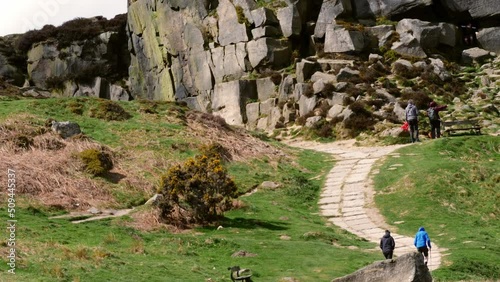 Hikers in Ilkley Moor rock formation in Yorkshire Dales England photo