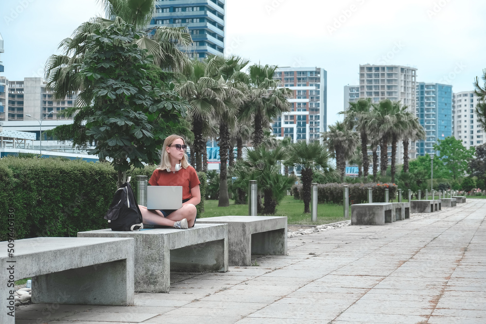 Remote work.Girl freelancer works remotely on the seashore.workation, remote work,WFVH,Van Life vibes work from vacation home,work travel,remotely work.Travelling