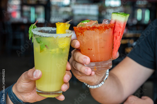 Two fruity cocktails cheersing