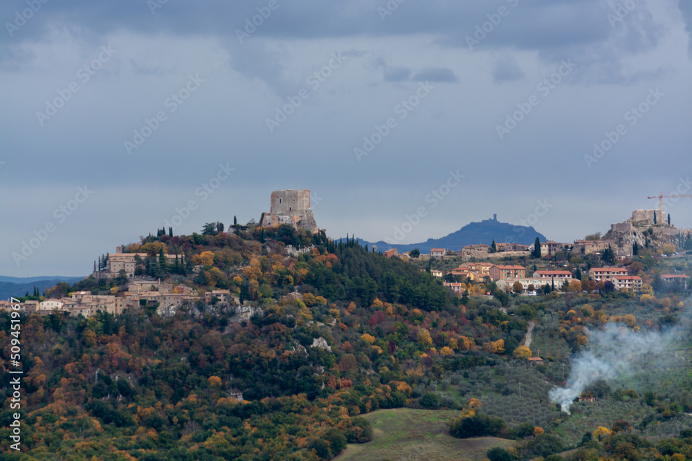 Tuscan hills in autumn, Medieval fortification castle on hilltop in Tuscany, Italy