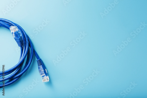 A coil of an Internet network cable for data transmission on a blue background photo