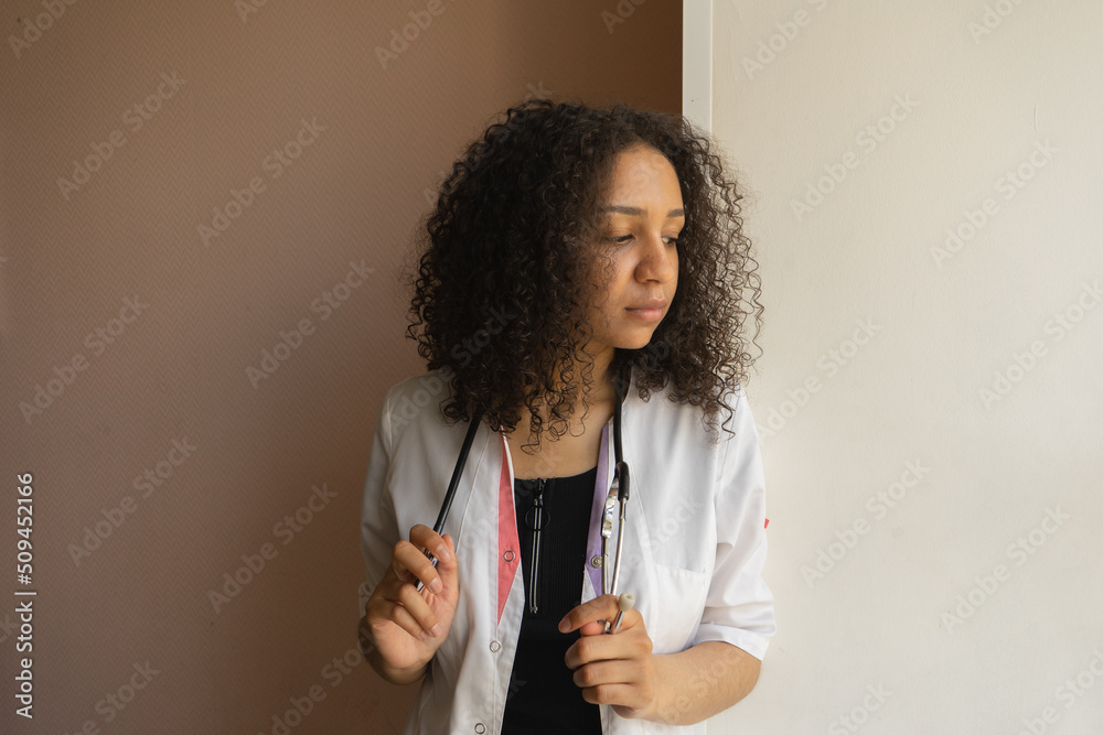 Young doctor with stethoscope in modern office, looking thoughtful. Young doctor with stethoscope in modern office, looking thoughtful.