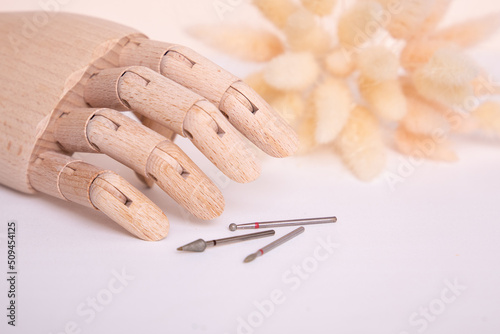 Wooden hand holding nail instruments. Manicure and nail care concept.