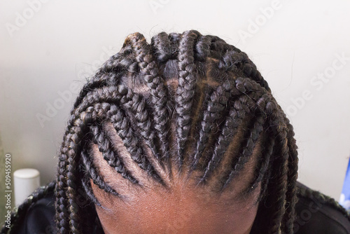 Young afro with  Boxer braids, African hair style also known as "Kanekalon braids." Close up on decoration and style.