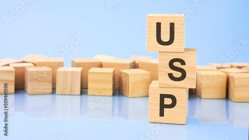 on a bright blue background, light wooden blocks and cubes with the text usp photo