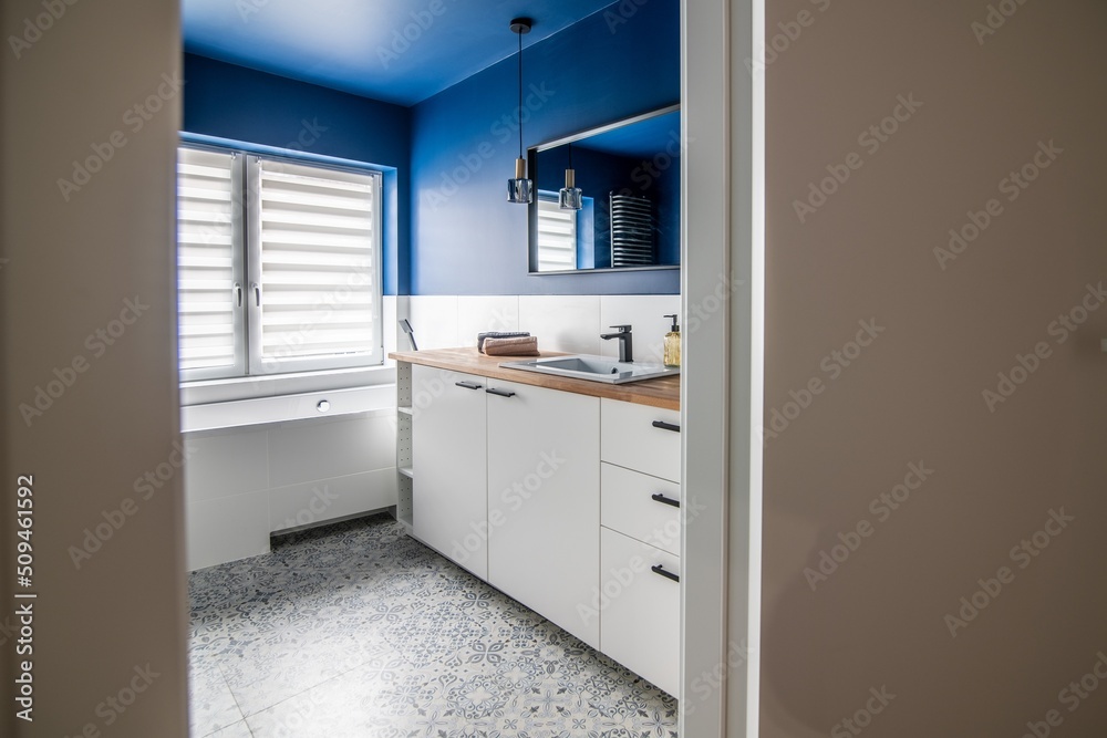 Entrance to the bathroom in a modern apartment. Bathroom door with blue walls and bathtub Entrance to the bathroom in a modern apartment. Bathroom door with blue walls and bathtub