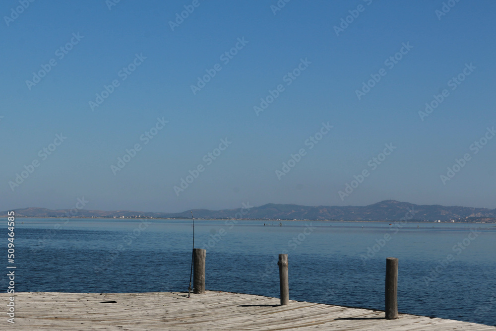 lagoon landscape from wooden pier and mountains and city background.