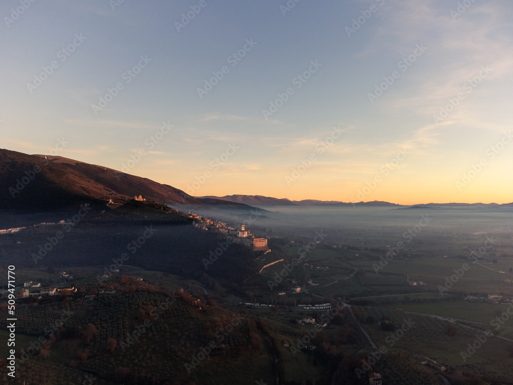 Drone view of Assisi Umbria Italy above mist at sunset