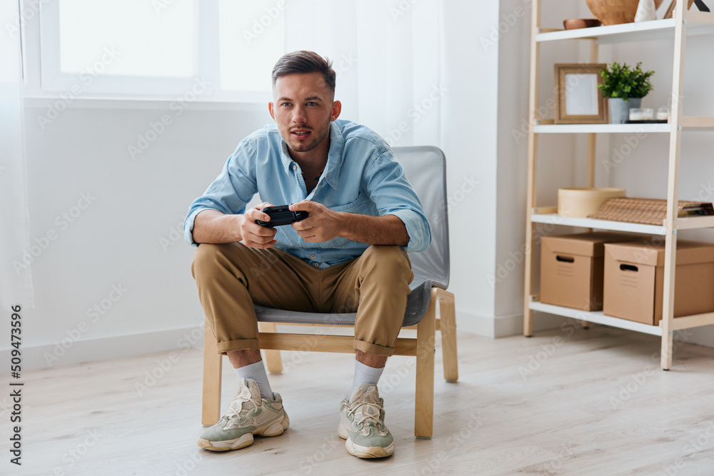 Player Stream Platform for gamers concept. Concentrated young tanned gamer hold joystick gamepad looks aside at screen at home. Relaxing Active recreation. Copy space for game console advertising