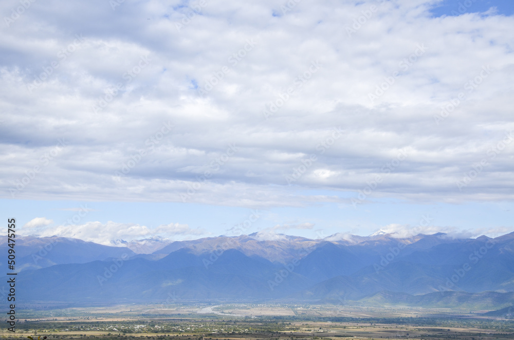 Scenery view to Alazani valley and Caucasian Mountain range at the distance from Telavi city, Kakheti region, Georgia Scenery view to Alazani valley and Caucasian Mountain range at the distance from Telavi city, Kakheti region, Georgia