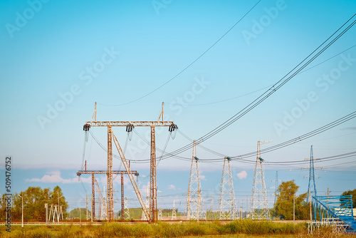 High voltage electricity tower with power line against blue sky. Overhead electric power line with insulators. Electricity generation, transmission, and distribution network. Indastry landscape. photo