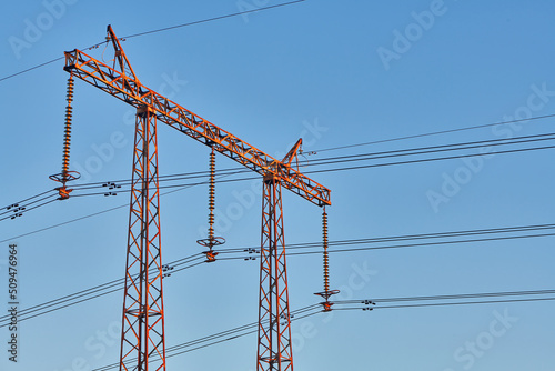 High voltage electricity tower with power line against blue sky. Overhead electric power line with insulators. Electricity generation, transmission, and distribution network. Indastry landscape. photo