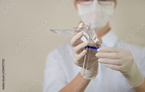Fotografía Doctor in medical uniform holds disposable gynecological speculum mirror
