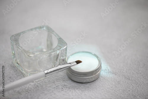 Brush and eyebrow styling wax jar. Selective focus, close-up.