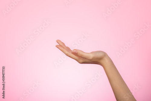 Woman's hand on pink background. Female hands ready for product placement concept. Skin and body care concept.