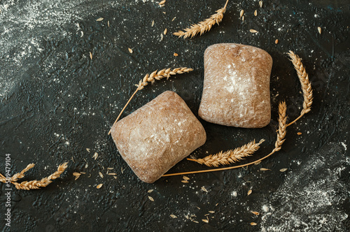 Two rolls of ciabatta on a black background with copy space. Top view, flat lay