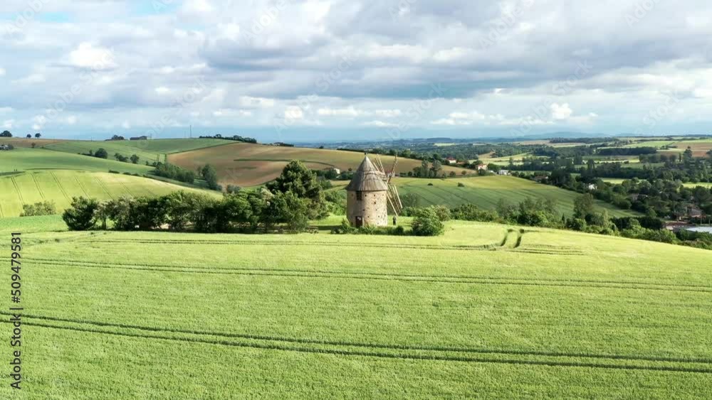 moulin à vent et champ de blé surplombant la campagne française	