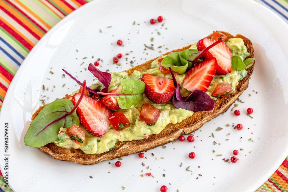 Keto diet avocado toast with strawberries, soft cheese, sesame seeds and herbs. healthy Breakfast or lunch. sandwich recipe mix media. top view, selective focus Keto diet avocado toast with strawberries, soft cheese, sesame seeds and herbs. healthy Breakfast or lunch. sandwich recipe mix media. top view, selective focus