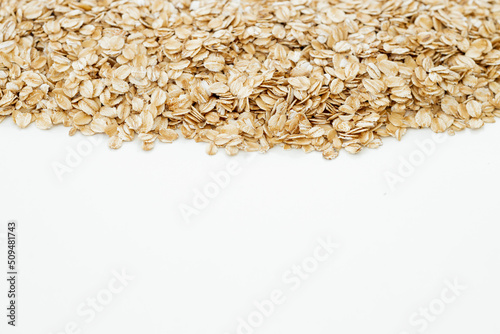 Oat flakes scattered on white background. Copy space, high resolution product
