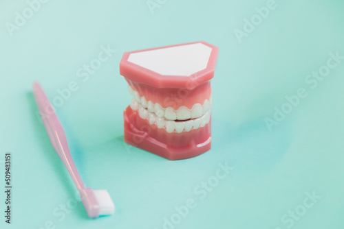 3d render of invisalign removable and invisible retainer and tooth brush over blue green  background photo