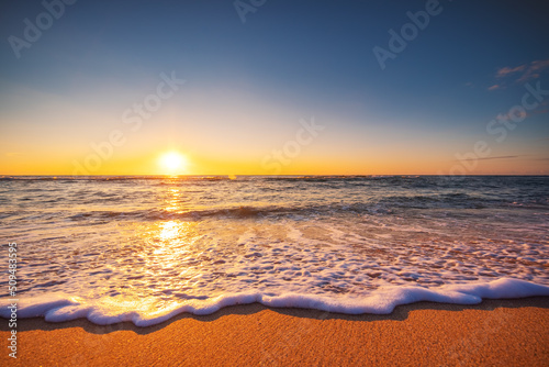 Beautiful sunrise over the sea waves and beach. Island in the ocean.