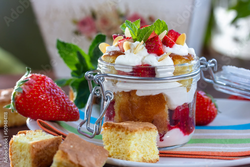 Layered Dessert of chocolate sponge cake, whipped cream or ricotta and fresh strawberries in a glass bowl. Trifle. Delicious gourmet breakfast.