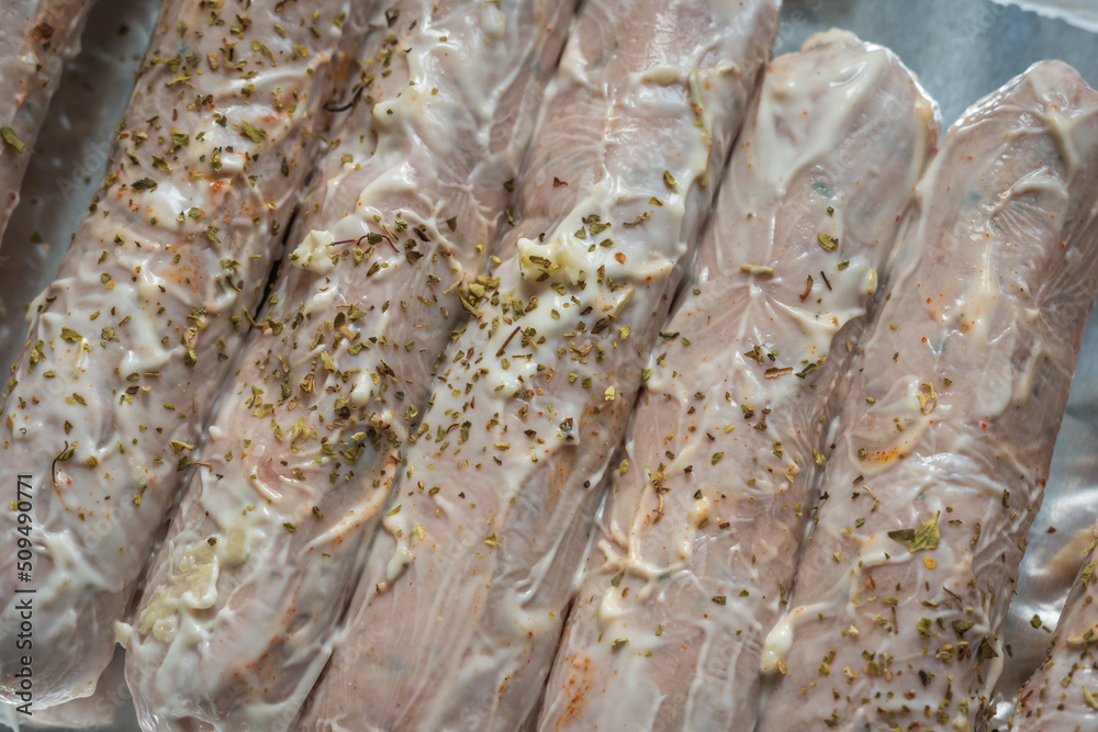 Raw seasoned sausages on baking tray closeup Raw seasoned sausages on baking tray closeup