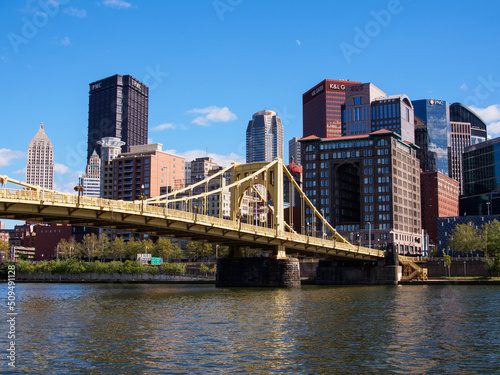 Yellow bridge and Pittsburgh downtown against blue sky. © Karlsson Photo