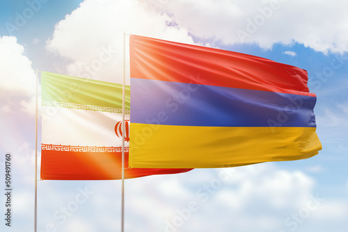Sunny blue sky and flags of armenia and iran
