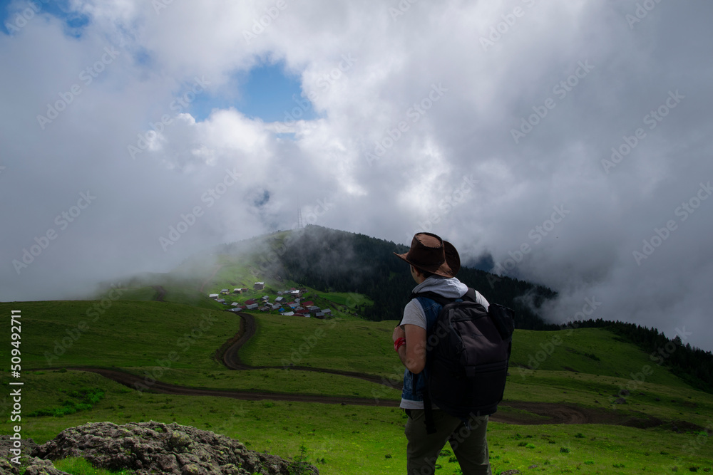 Obraz premium Rize, Turkey - July 2016: A tourist watching the sea of clouds on the high plateau. Photo was taken in plateau in Rize, Karadeniz region of Turkey. 