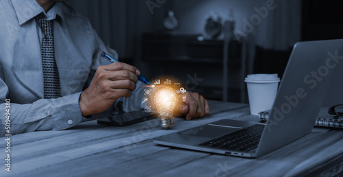 Obraz na płótnie Businessman hand holding creative light bulb with marketing network icons on planning strategy, analysis solution and development, Modern business, Innovative of new ideas. w salonie