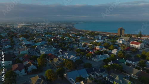 Aerial view of residential borough near sea coast lit by setting sun. Sea bay in background. Port Elisabeth, South Africa