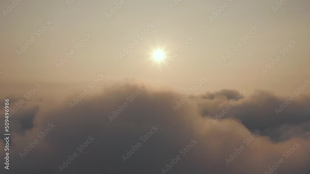 Cinematic view from the cockpit to the fluffy cumulus clouds and sun: Sun above the clouds: sunset at high altitude above the fog. The movement of clouds against the background of the sun and sky. Cinematic view from the cockpit to the fluffy cumulus clouds and sun: Sun above the clouds: sunset at high altitude above the fog. The movement of clouds against the background of the sun and sky.