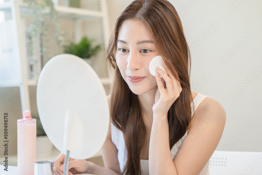 Young asian woman applying moisturizer on face after use toner cleansing remove cosmetic. Young asian woman applying moisturizer on face after use toner cleansing remove cosmetic.