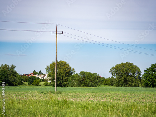 droga elektryczna na środku łąki, krajobraz w rejonie zachodniej polski zielone drzewa błękitne niebo