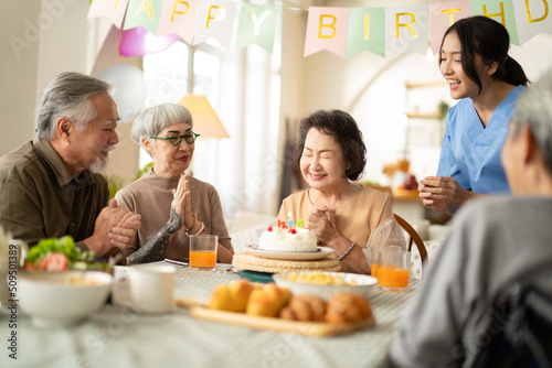 birthday party at senior in Adult Daycare Center concept.Group of asian elder people friends having birthday party in the living room at nursing home enjoy smile happiness in birthday friend party