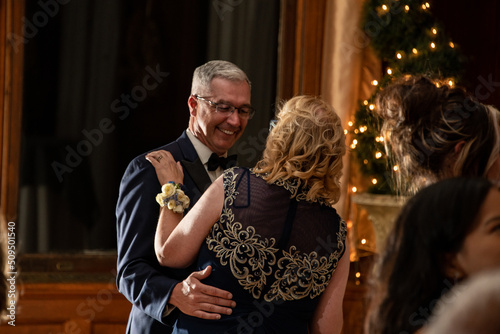 Cute older couple dancing at a party reception with lights