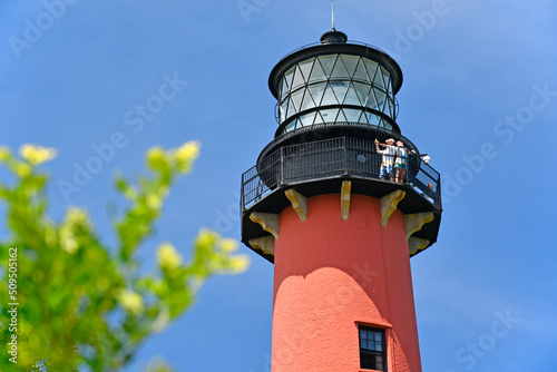 Tourists visting the top of historic Jupiter lighthouse under blue skies at Jupiter Inlet, Florida