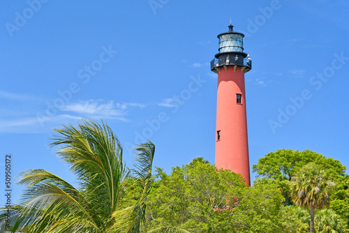Historic red brick lighthouse against a clear blue sky in Jupiter, Florida